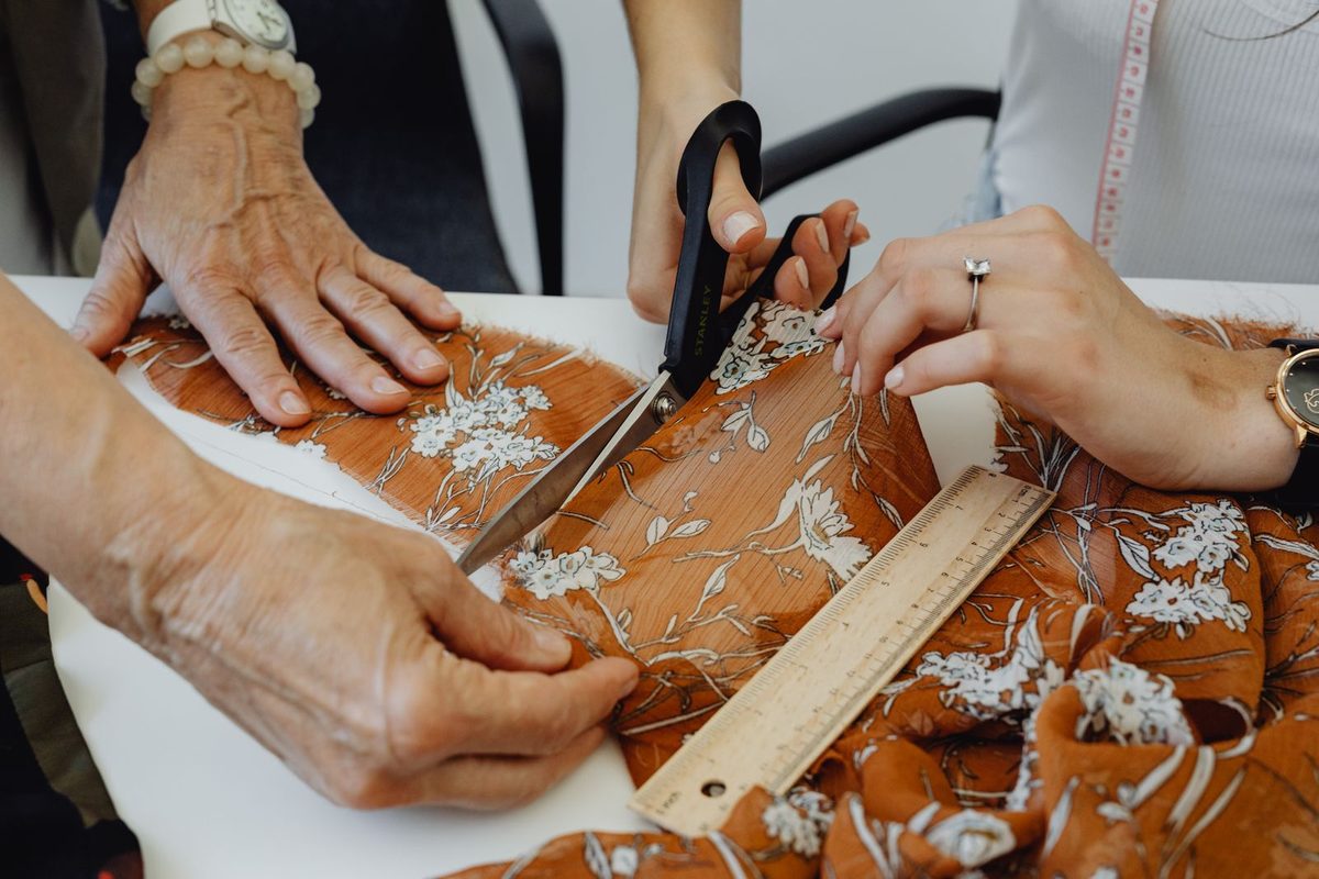Patterned fabric being measured and cut on a workroom table
